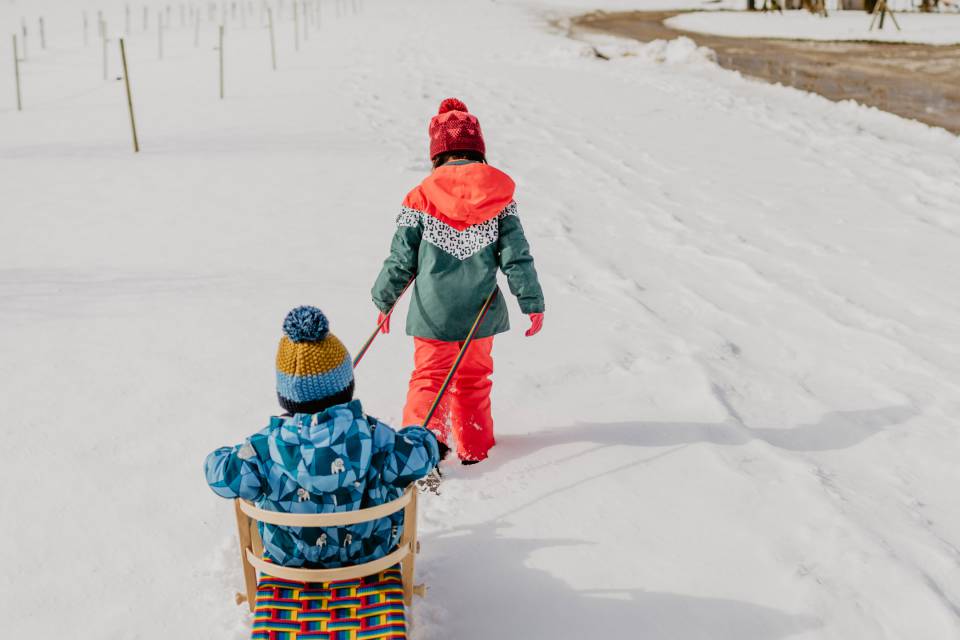 Kinder mit dem Schlitten im Schnee