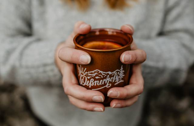 Frau mit Weßner Hof Tasse in der Hand