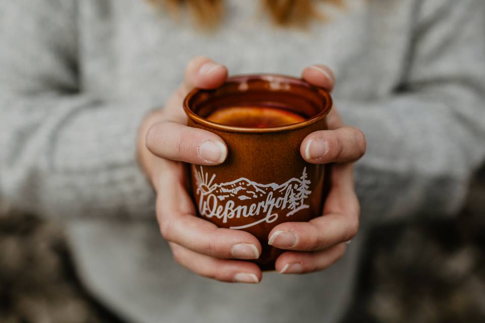 Frau mit Weßner Hof Tasse in der Hand