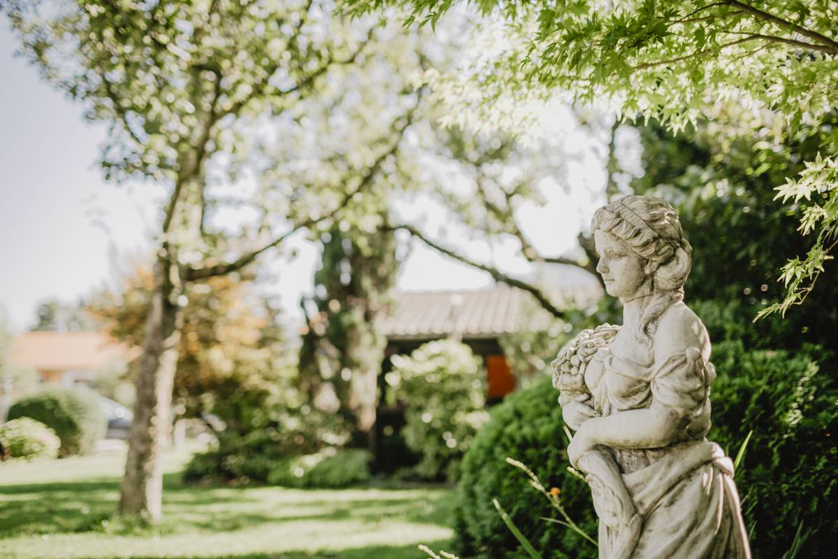 Frauen Statue im grün blühenden Hotelgarten des Weßnerhofs 