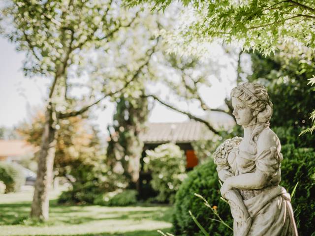 Frauen Statue im grün blühenden Hotelgarten des Weßnerhofs
