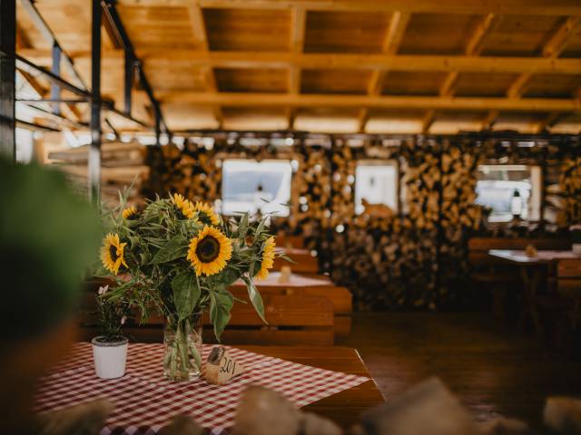 Frische Sonnenblumen auf Holztisch im überdachten Außenbereich des Hotels Weßnerhof in Bayern