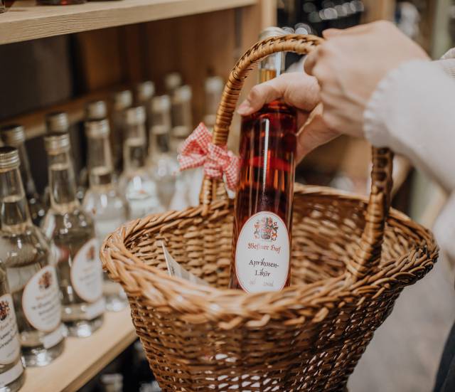 Person legt Schnapsflasche in den Krob