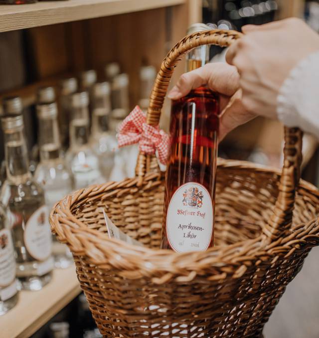 Person legt Schnapsflasche in den Krob