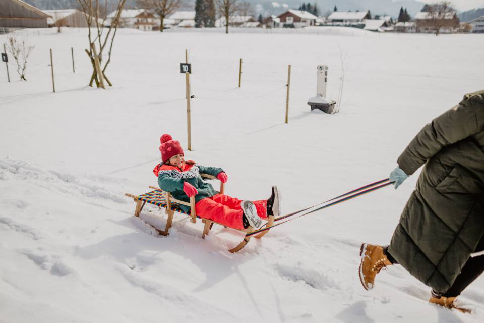 Winter-Schlittenfahren-Kind